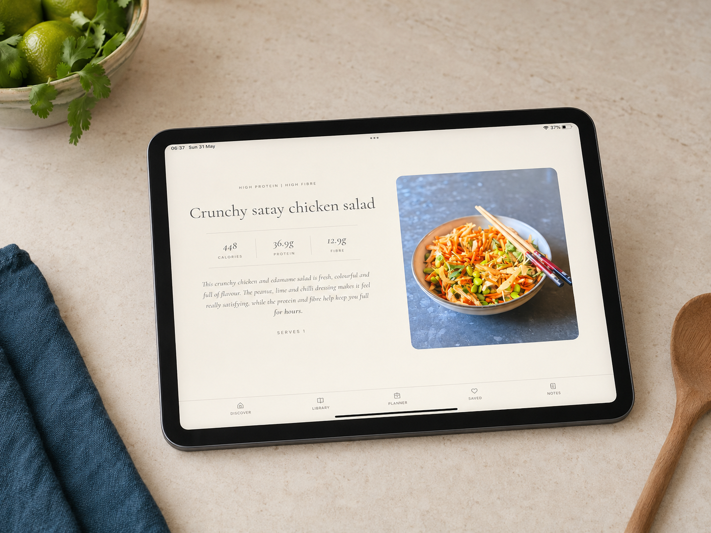 The Finding Balance app open on a tablet on a kitchen surface, showing a crunchy satay chicken salad recipe